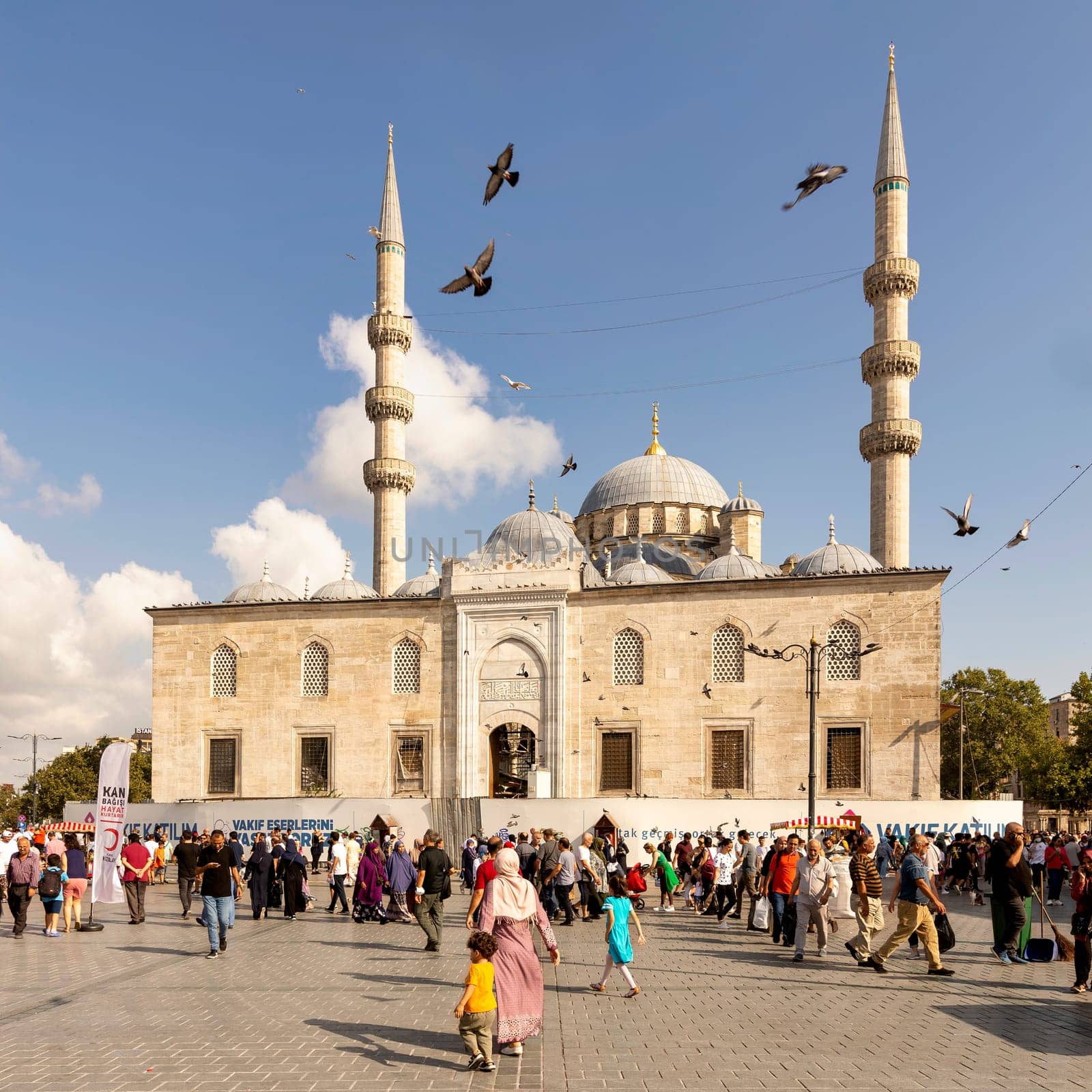 Istanbul, Turkey - August 30, 2022: Crowds of local citizens at Eminonu during the Victory Day holiday with the New Mosque, or Yeni Camii in the background