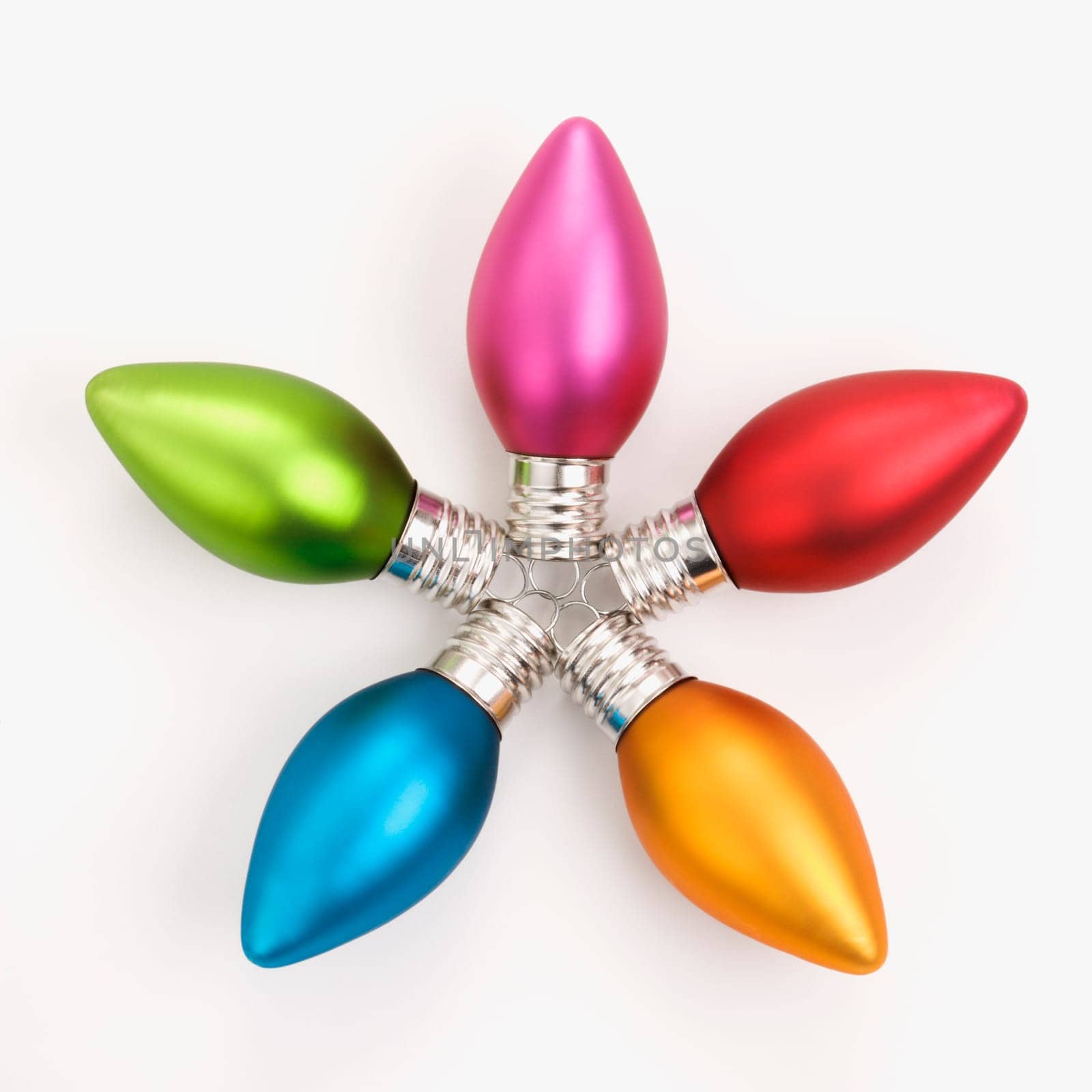 Still life of multicolored Christmas ornaments arranged in star shape.