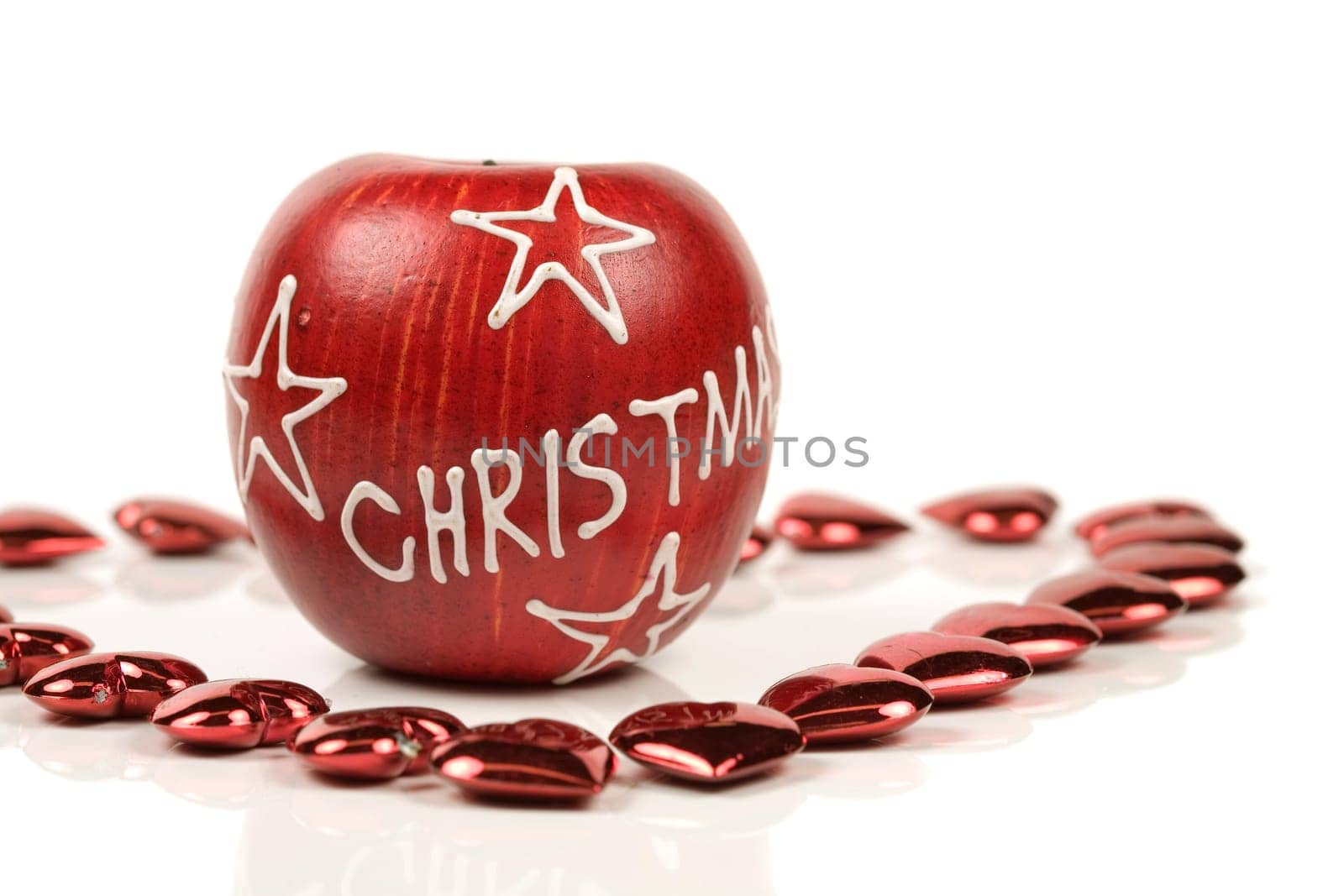 Christmas apple surrounded by little red hearts on white background