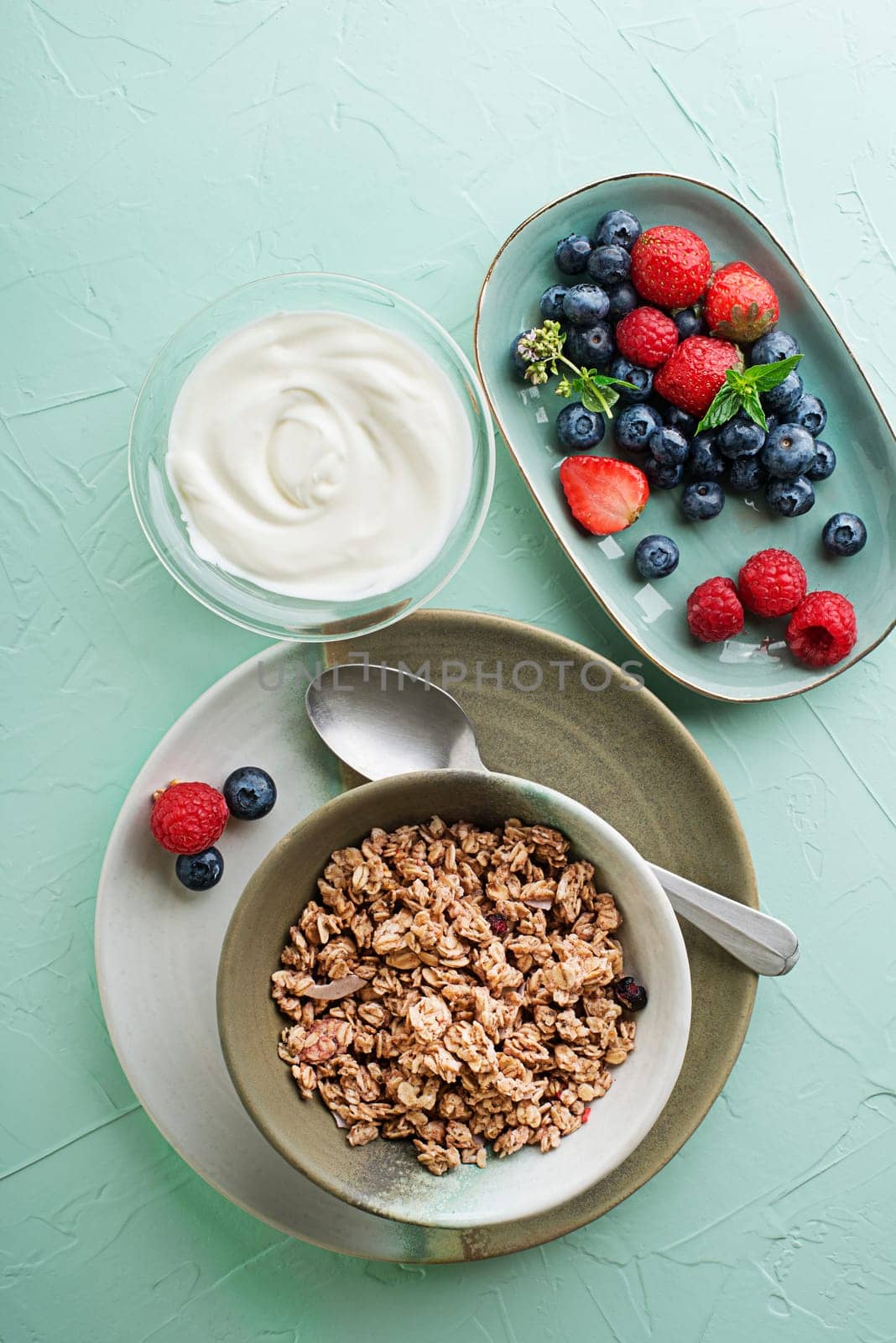 A plate of dry granola served with fresh berry fruit and yogurt. Oatmeal plate. Healthy food, diet. Top view.