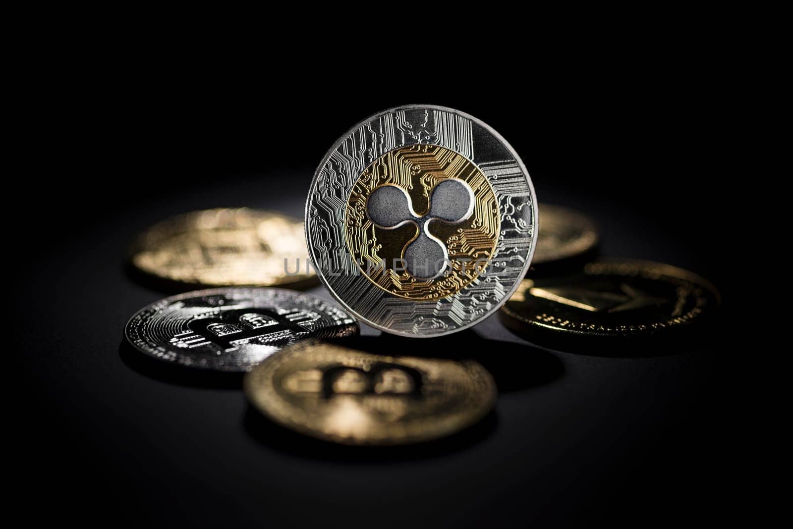 Bitcoin and altcoin cryptocurrency investing concept. Cryptocurrency coins with ripple symbol in black background