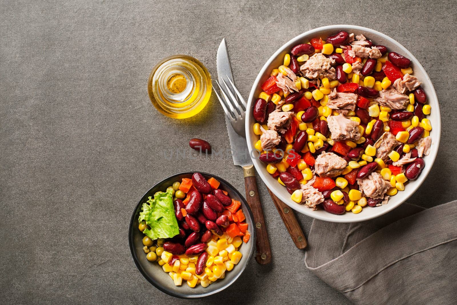 Healthy tuna salad with corn, peppers and beans on grey background. Mexican corn salad.