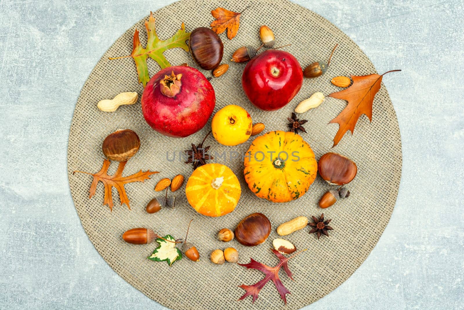 Set squash, autumn fruit, apples, and nuts on plate. Autumn still life