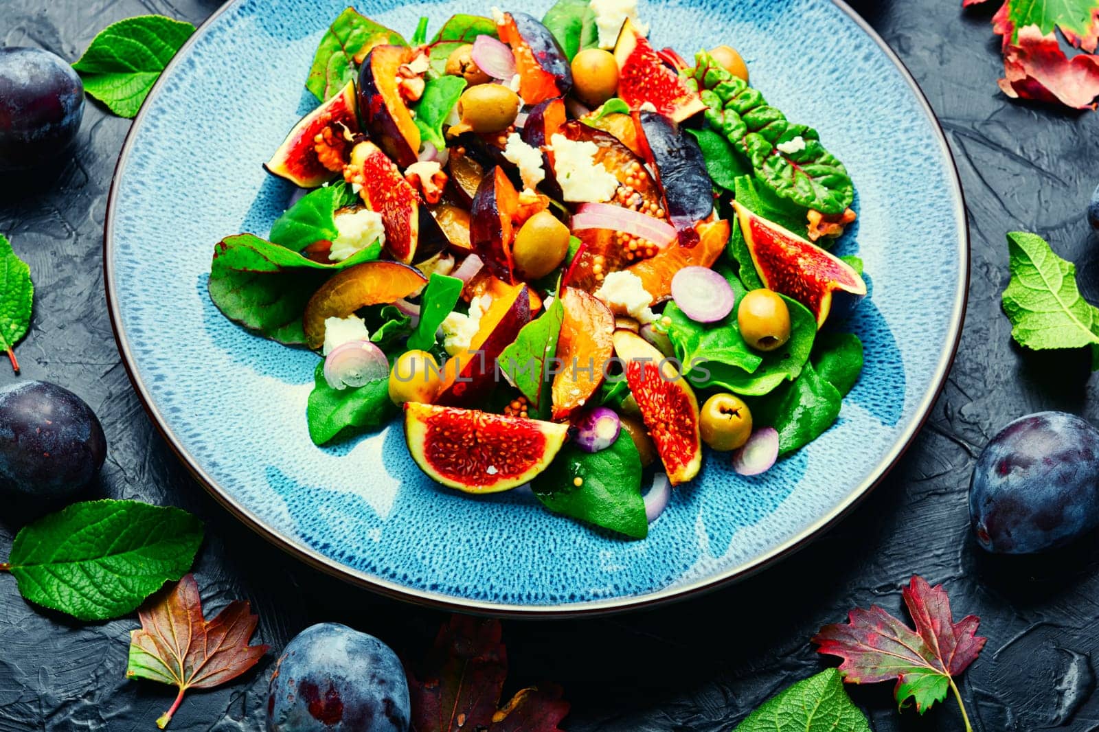 Unusual salad with figs, plums, herbs and olives. Natural salad