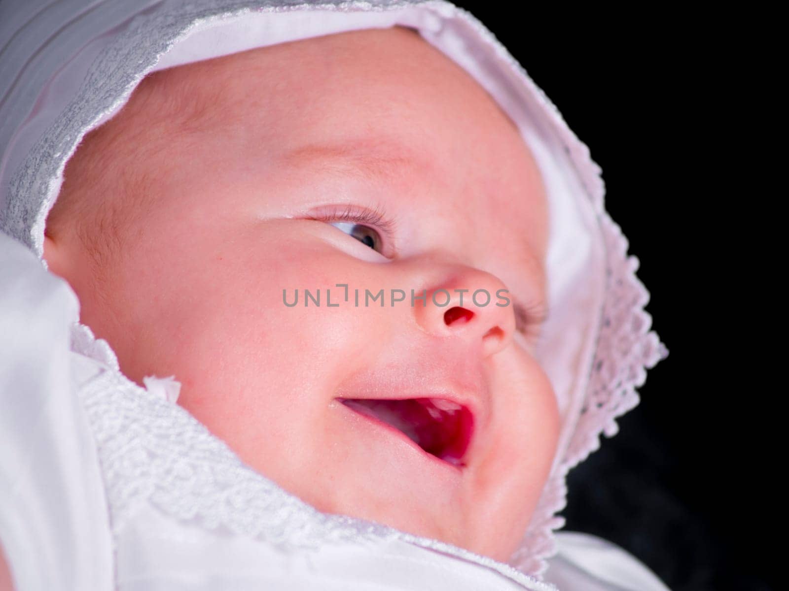 A portrait of a baby girl in a christening dress.