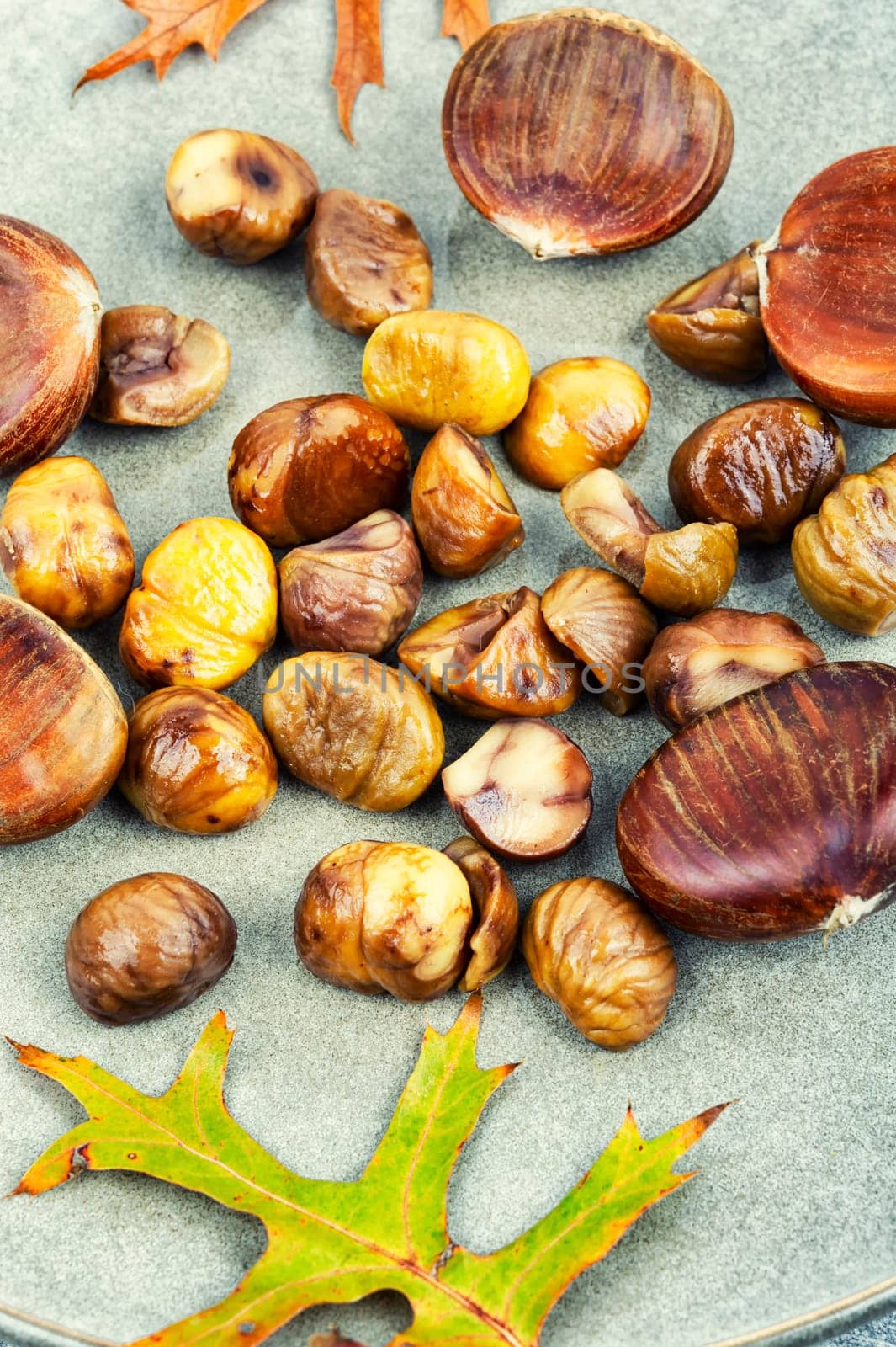 Roasted peeled chestnuts and autumn leaves.