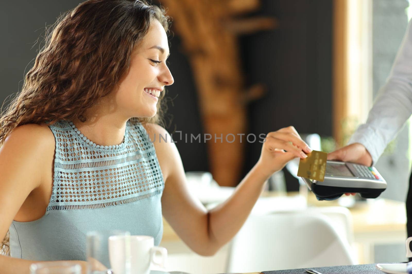 Happy customer in a restaurant paying with credit card