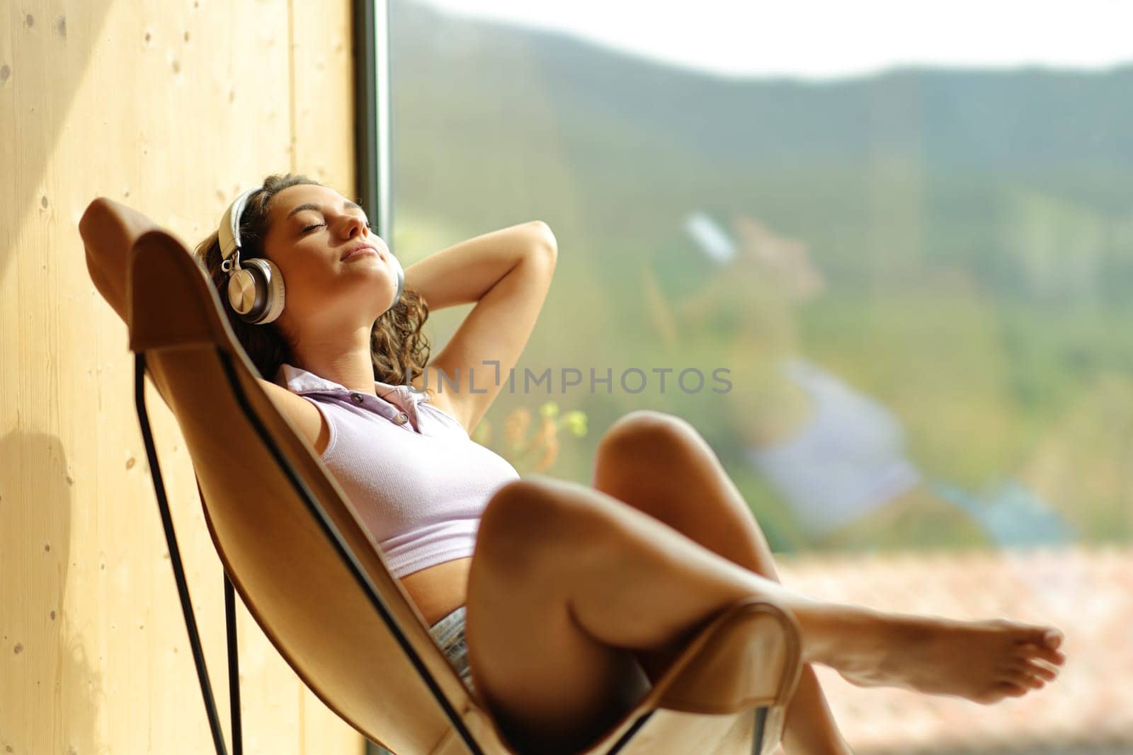 Woman listening to music relaxing sitting on a chair at home