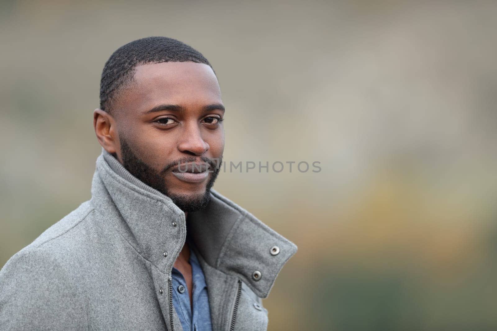 Confident black man looks at you in a park