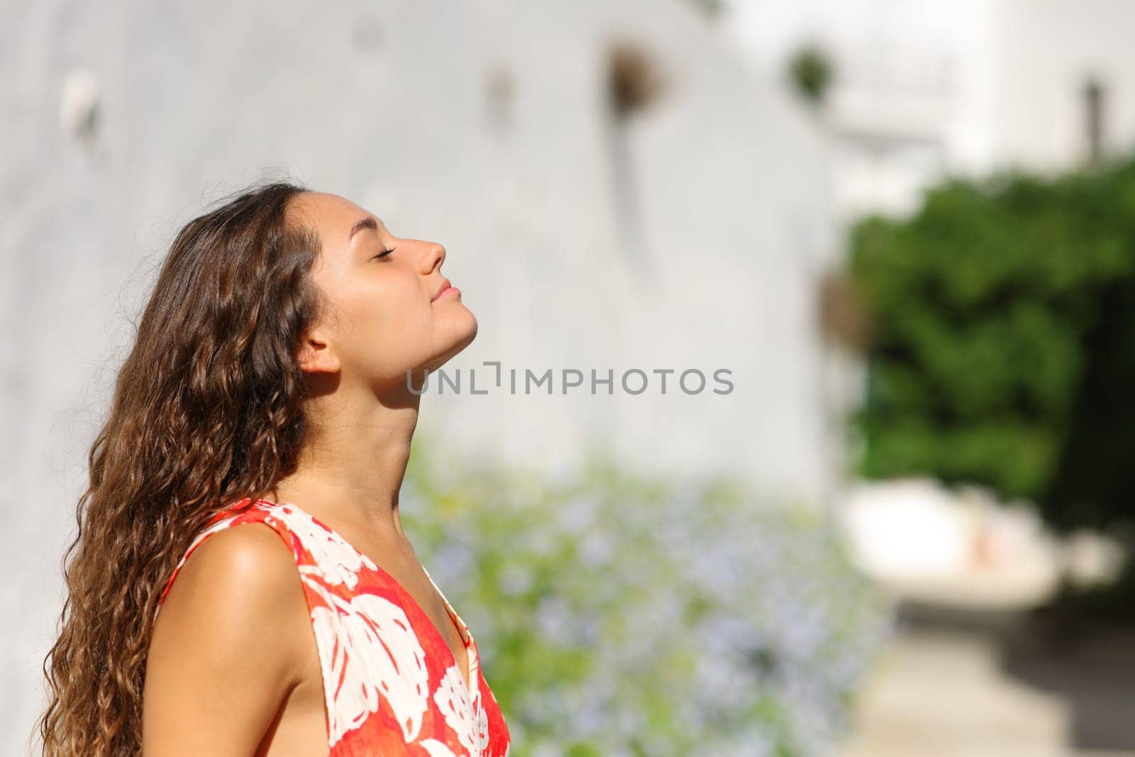 Side view portrait of a woman in a white town breathing fresh air