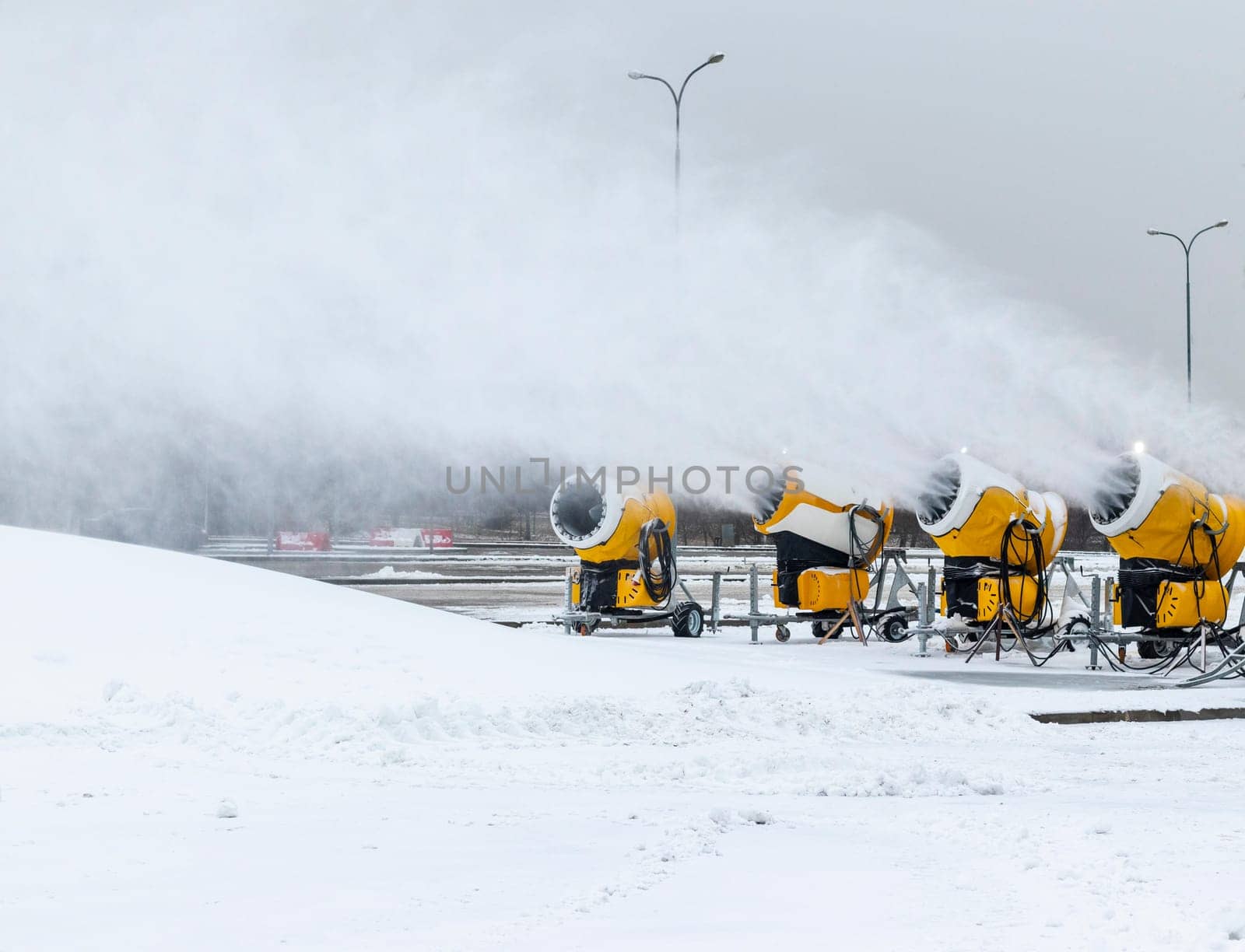 Shot of the industrial machinery so called snow gun or snow cannon that produces artificial snow in action.