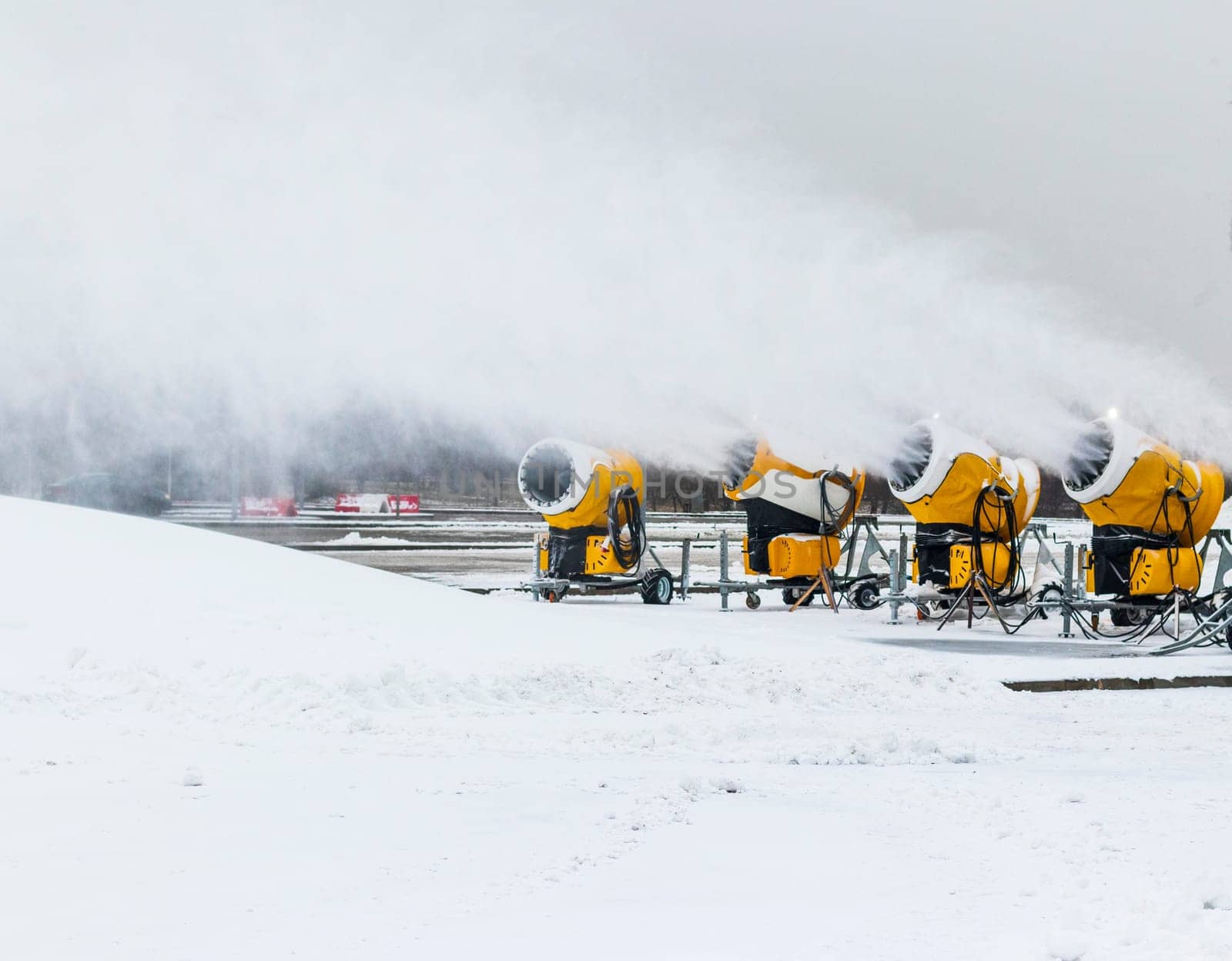 Shot of the industrial machinery so called snow gun or snow cannon that produces artificial snow in action.