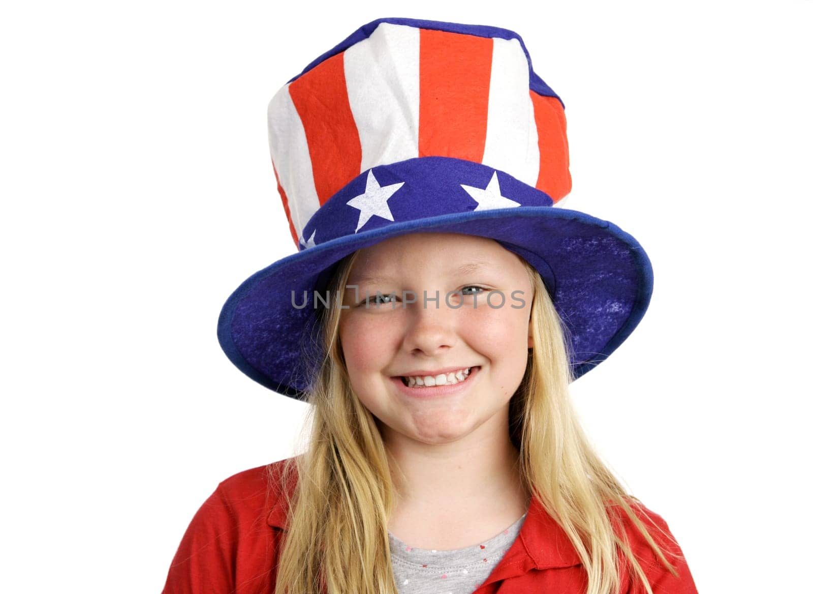 A pretty blond little girl smiling in a stars and stripes hat for Fourth of July.  Isolated on white.
