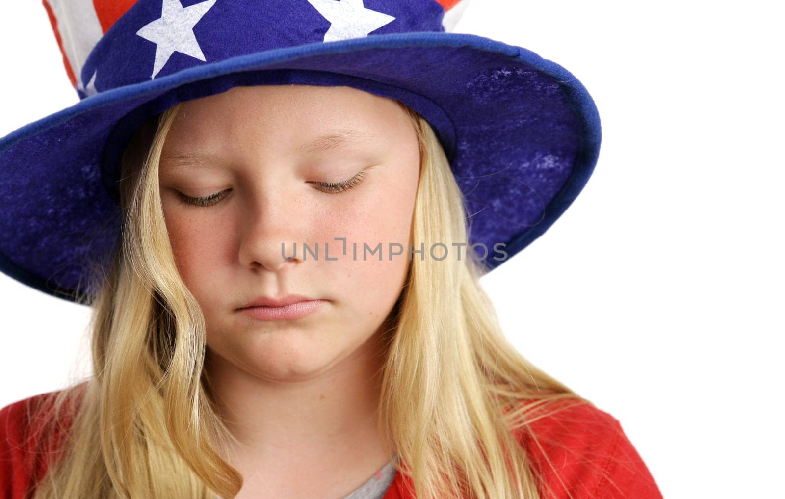 A beautiful young girl wearing a patriotic American hat and looking sad.