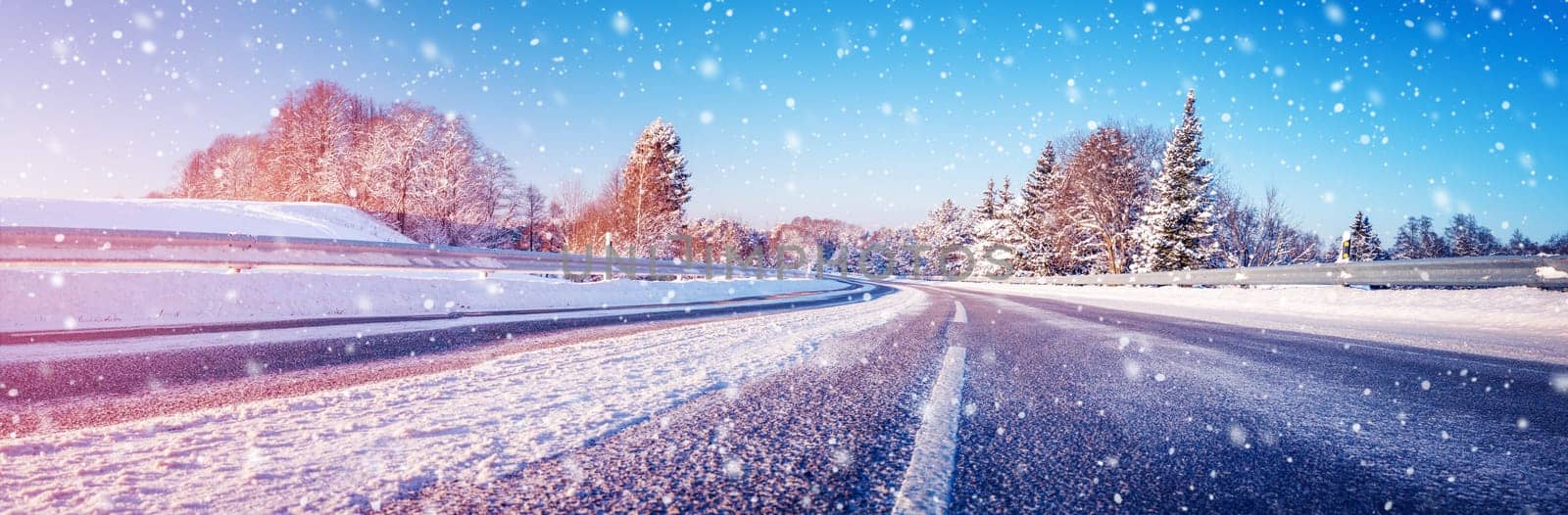 Panoramic view of the wide snowy road in winter. Scenery background of the asphalt highway.
