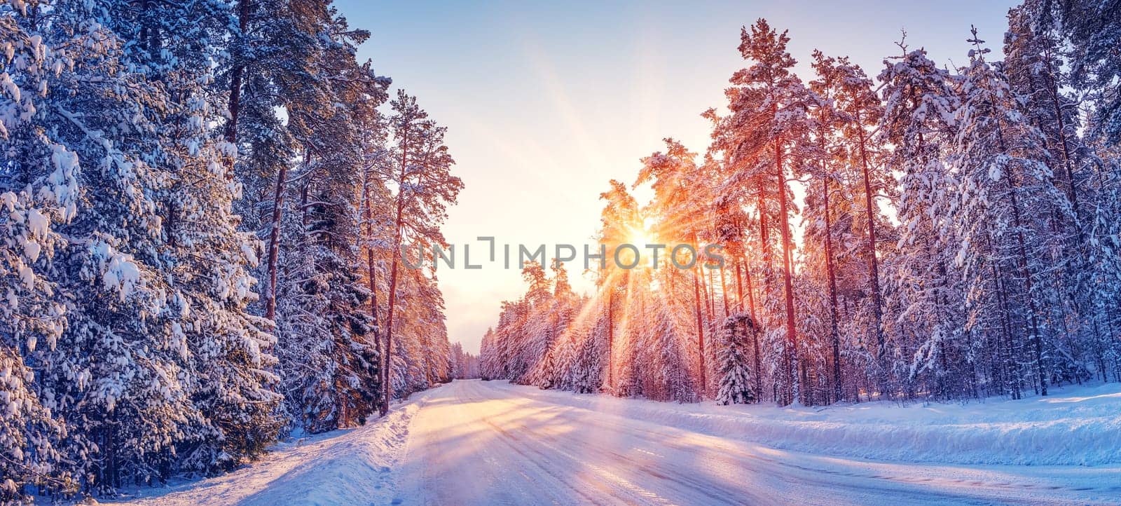 Beautiful view of the sunrise in the morning on the country snowy road. Scenery landscape.