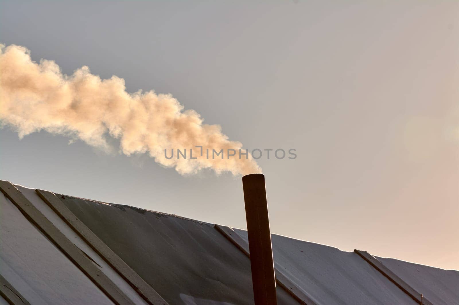 smoke is coming from the chimney of the bourgeoisie. the stove is being heated. High quality photo