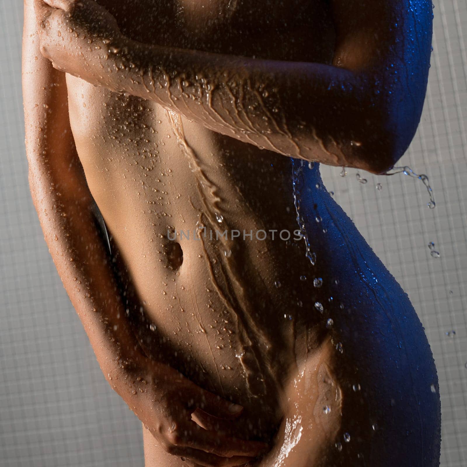 Nude young woman taking shower cropped profile view
