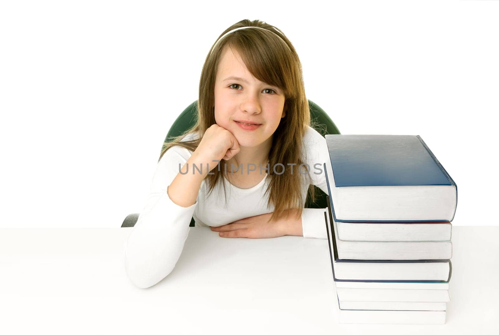 Portrait of Happy young schoolgirl smiling from behind book on a white background