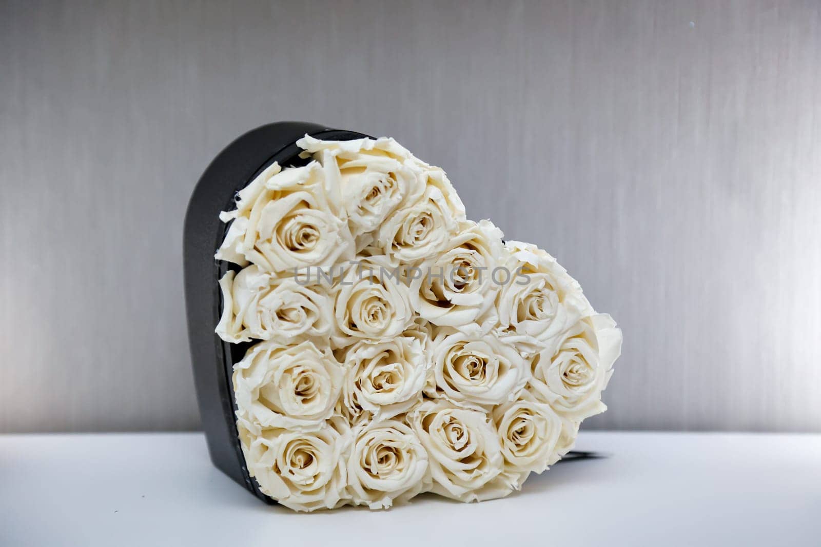 A heart box filled with many white roses. Motif for Valentine's Day.