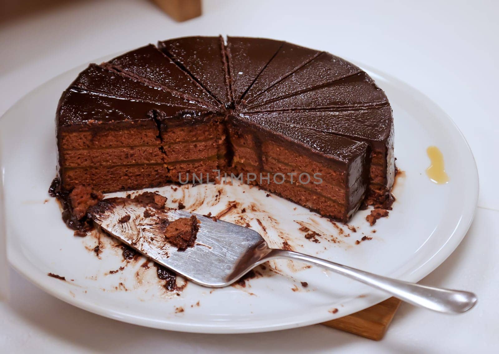 A cake, stands cut on a table.