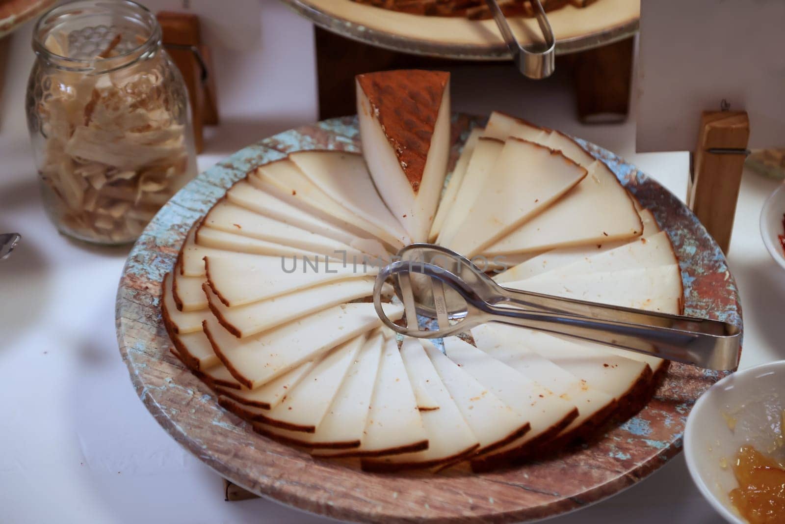 A cheese in the form of a cake with many slices of cheese.