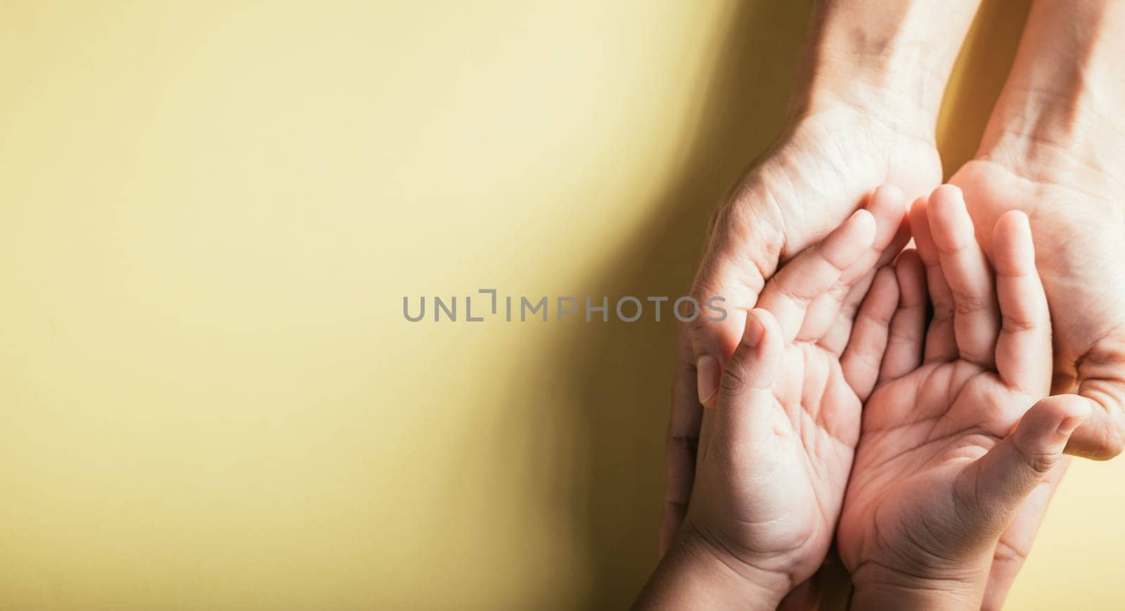 Close up hands children on adult mother hand, Top view person kid stack mom palms, Parents and little kid holding empty hands together isolated on yellow background, Family day care concept