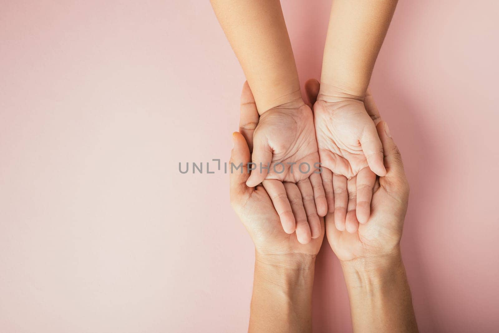 Close up hands children on adult mother hand, Top view person kid stack mom palms, Parents and little kid holding empty hands together isolated on pink background, Family day care concept