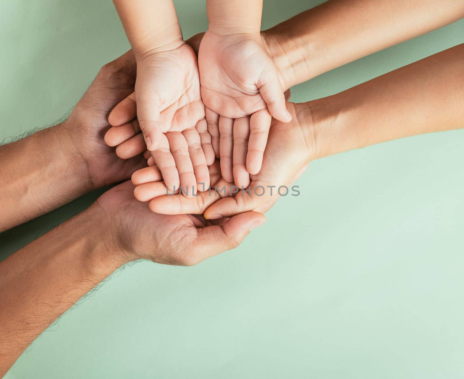 Top view parents and little kid holding empty hands together studio shot isolated on green background, family home, hands children on adult mother hand, help support, parents family day concept