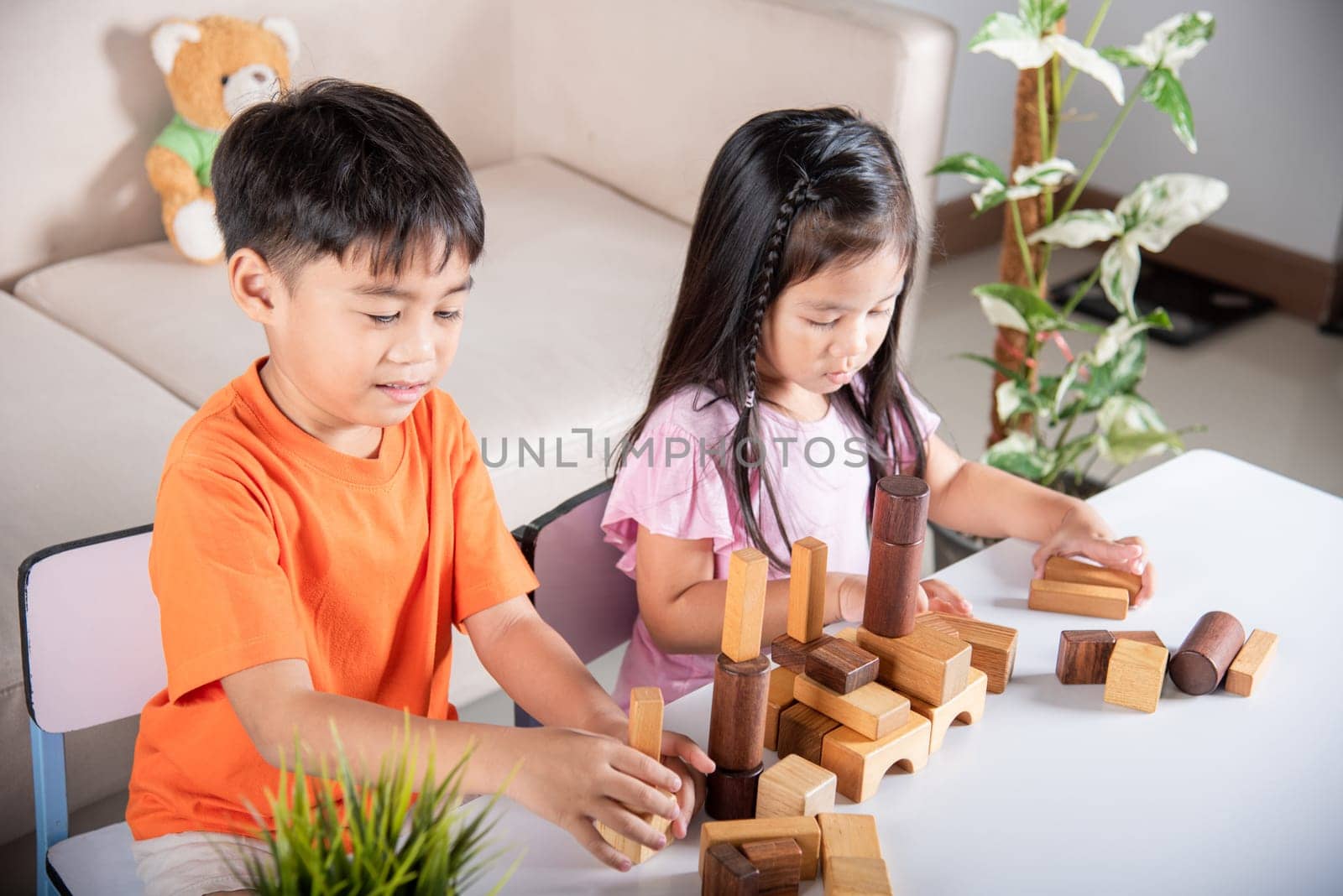 Children boy and girl playing with constructor wooden block building, Happy little kids play wood block stacking board game at home, activities learning creative, toys for preschool and kindergarten
