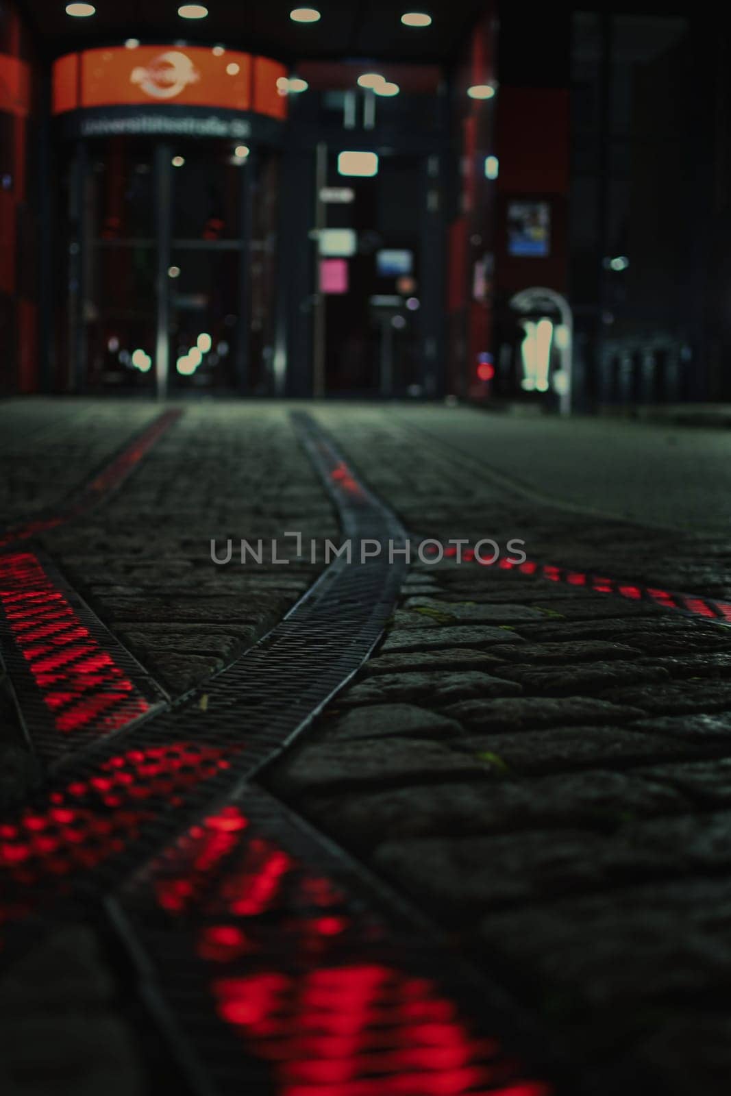 Red luminous rails on the forecourt in front of a headquarter in Bochum, Germany.