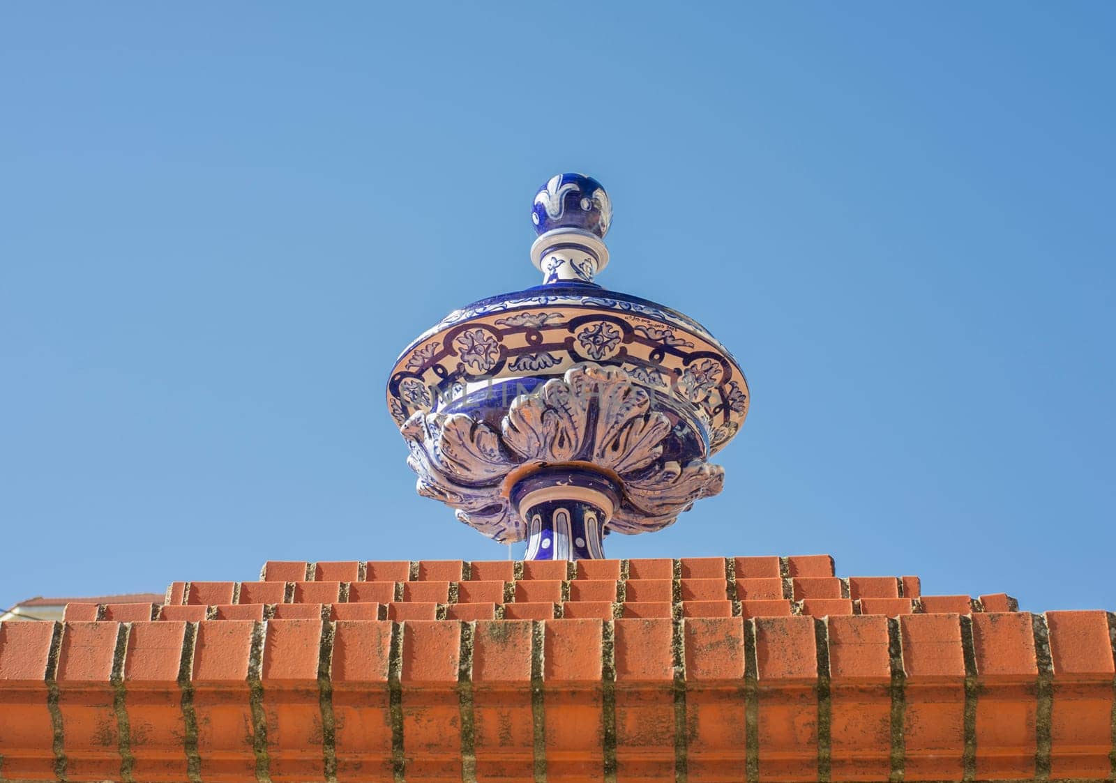 Ceramic top vase placed over brick wall. Espronceda Square, Almendralejo, Badajoz, Spain