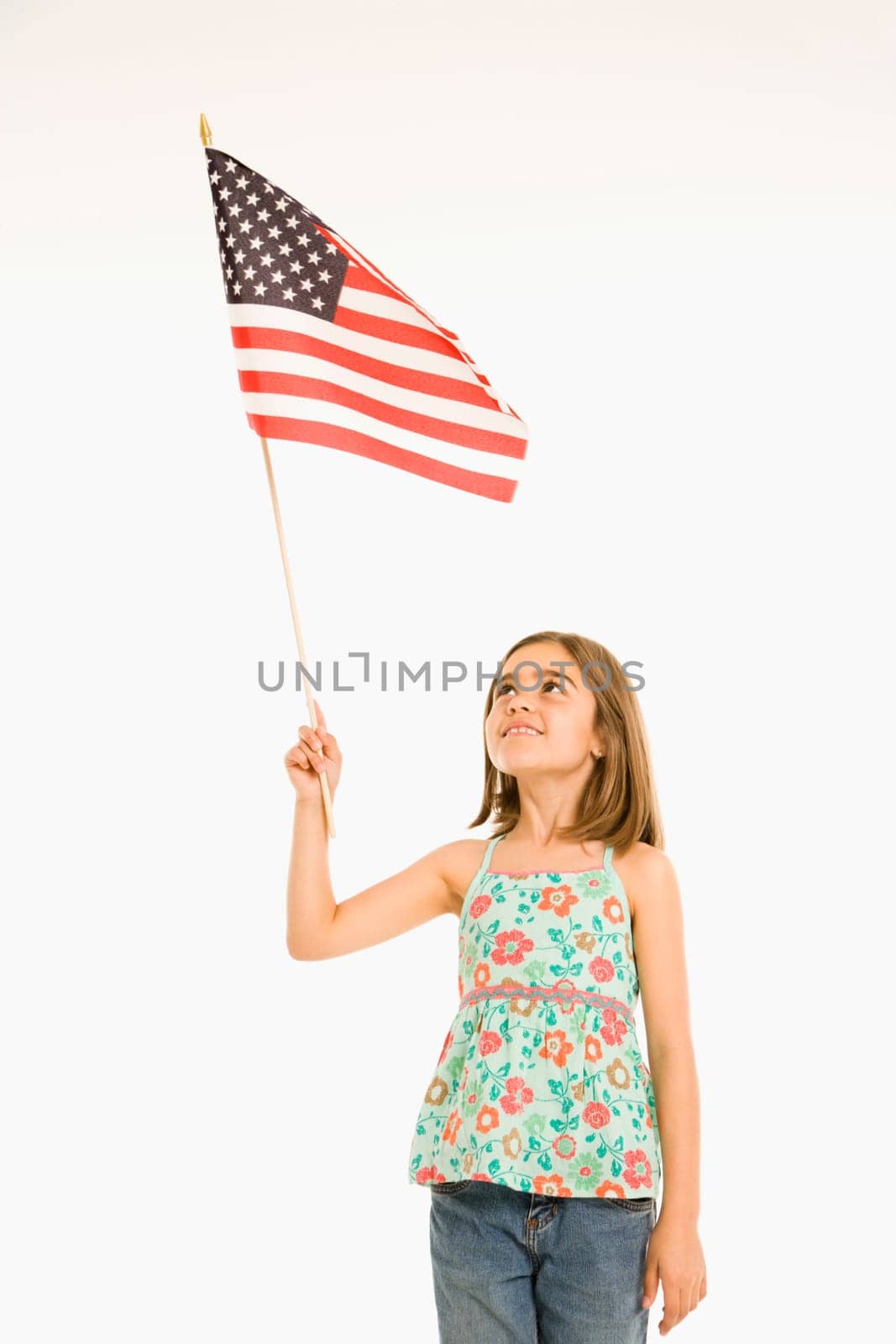 Girl holding American flag against white background.
