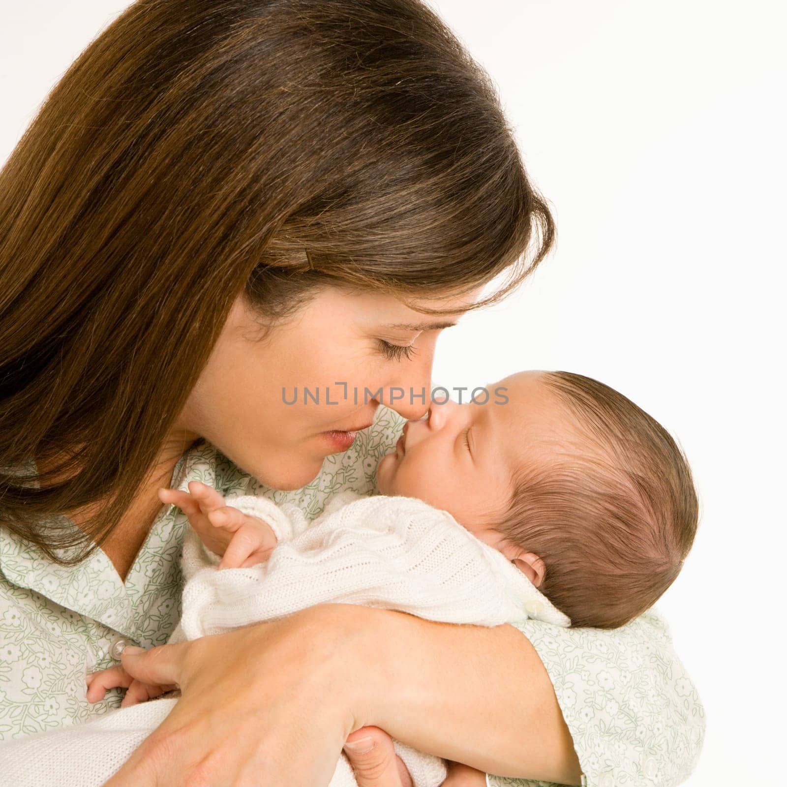 Mother nuzzling sleeping baby with nose and smiling.