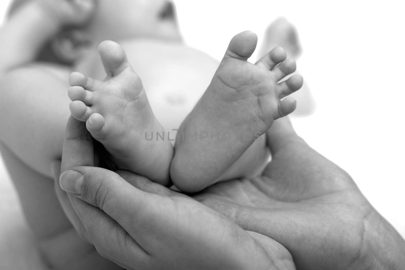 little feet of newborn baby in mother's hands