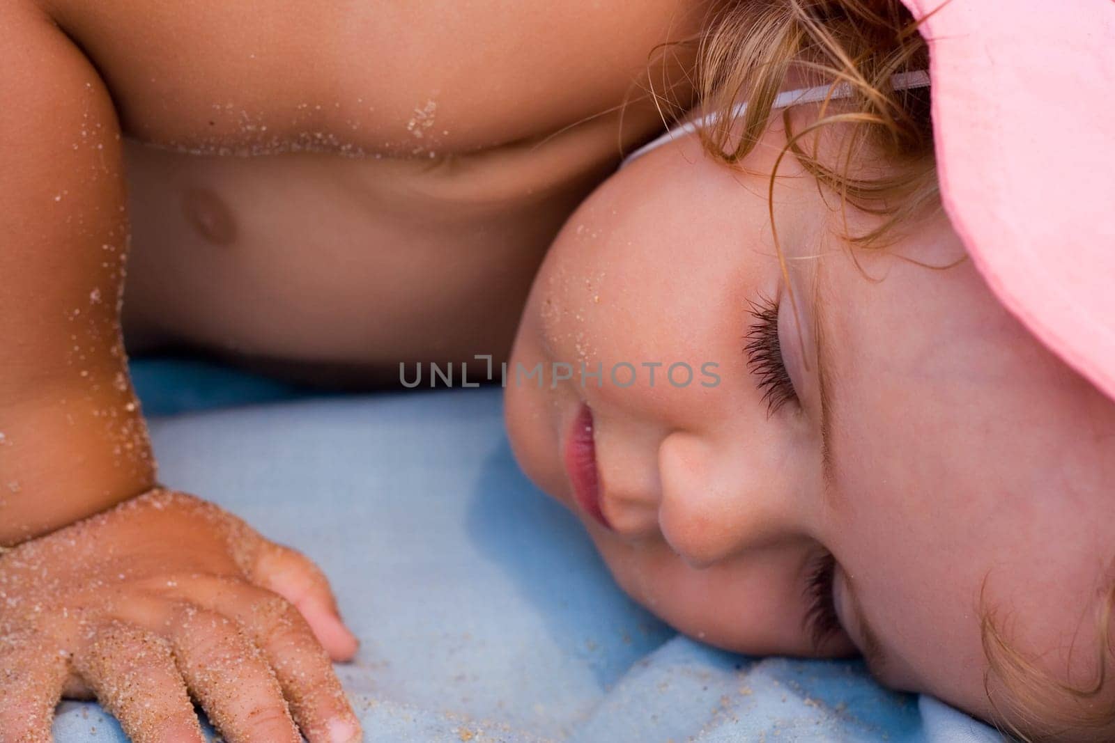 Baby girl taking a nap after playing on the beach