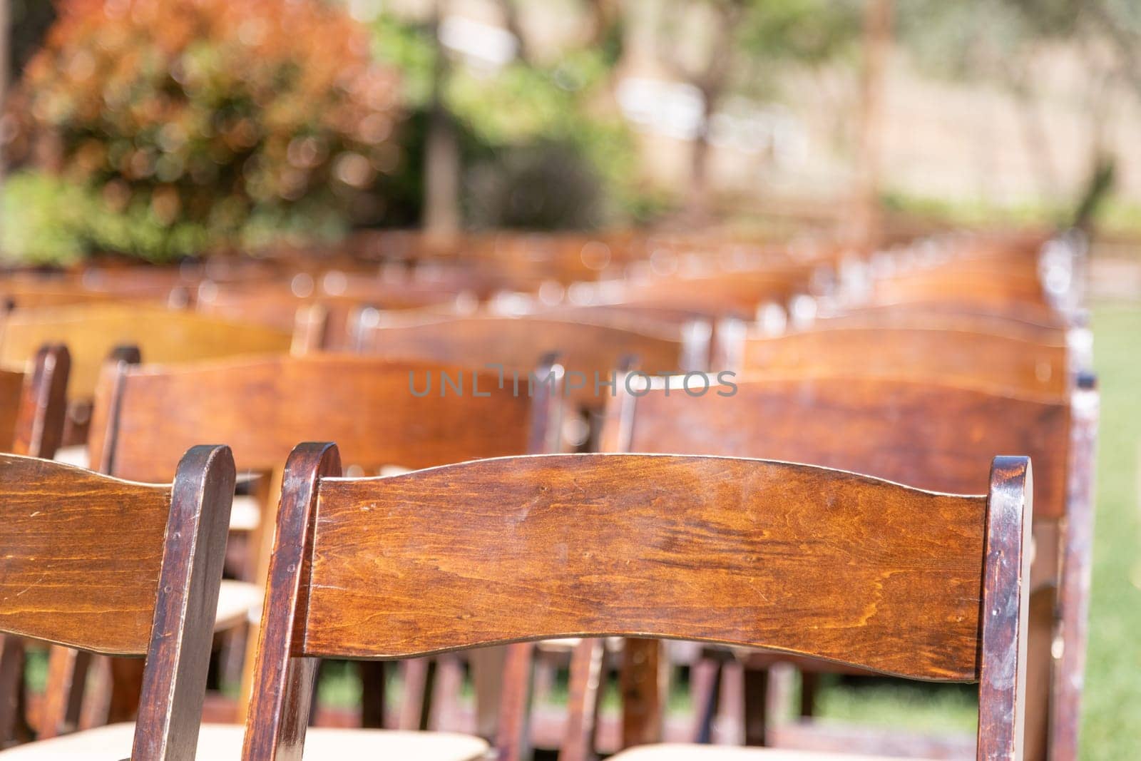 Rows of Wooden Event Chairs at Wedding Venue Abstract.