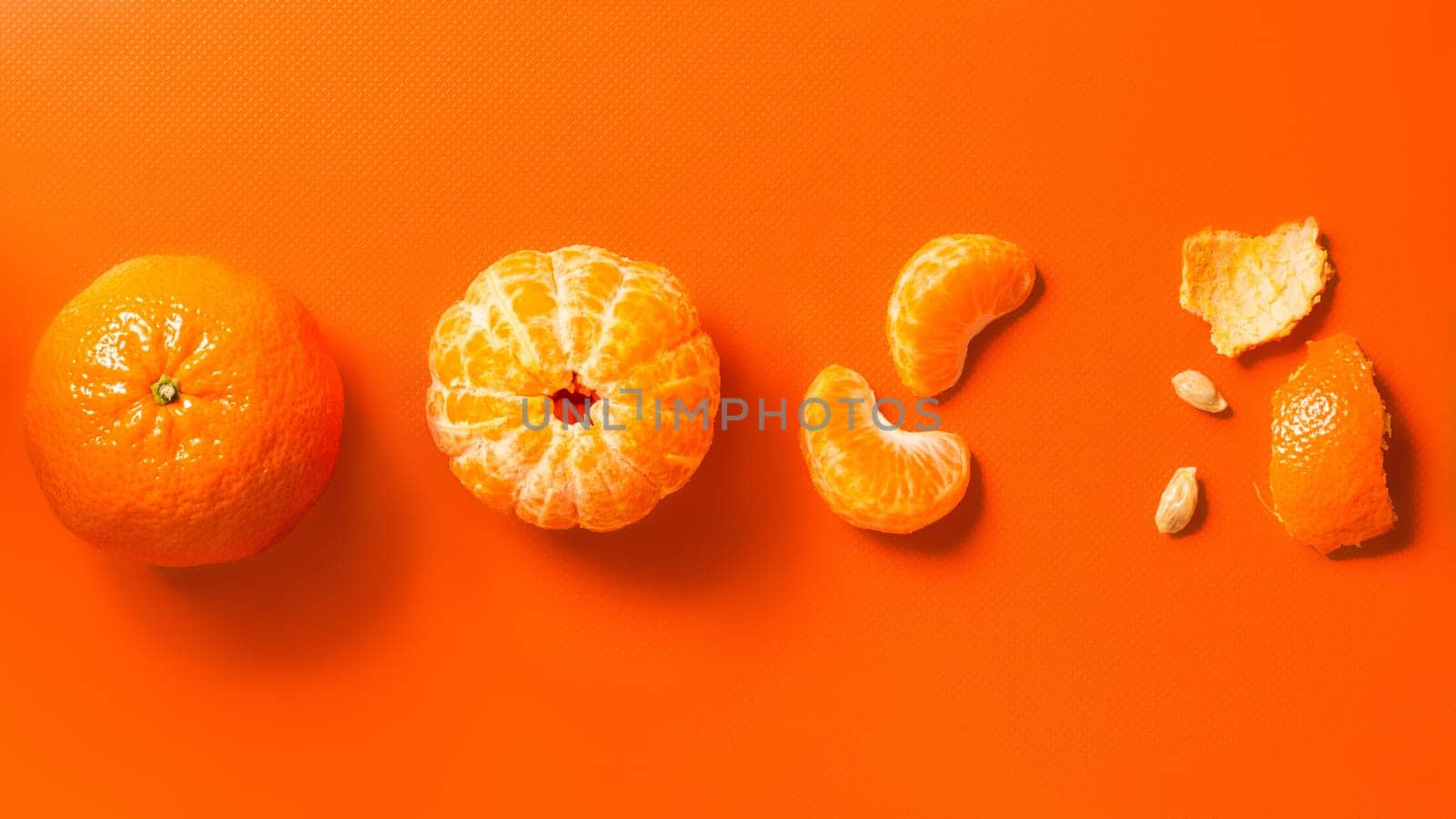 Tangerines on an orange background: whole, peeled, wedges and peels. Flat lay, banner