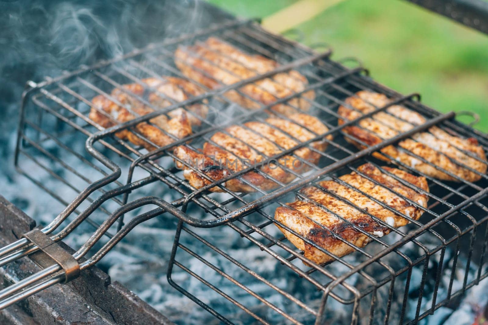 Raw grilled pieces of meat on barbecue grill are cooked on charcoal grill. Cooking BBQ outdoors