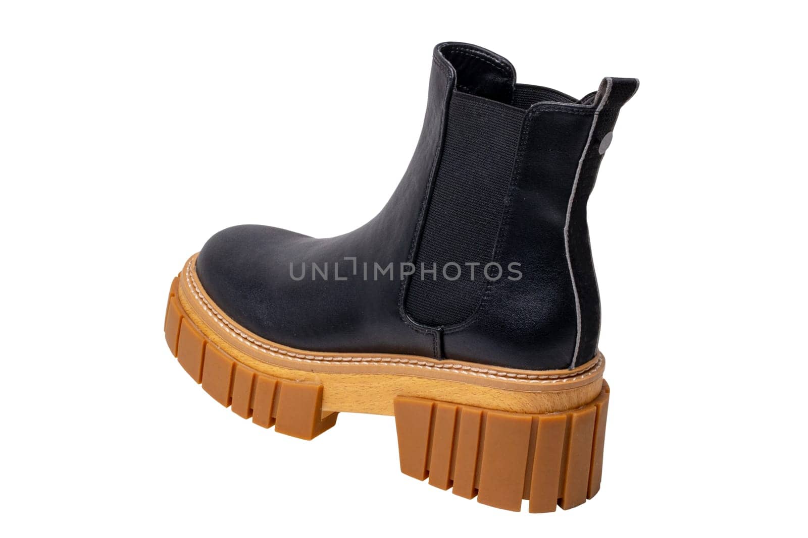 Ladies Chelsea boots. Close-up of a single womens black leather chelsea boots with high heels isolated on a white background. Macro. Fashion advertisment shoes.