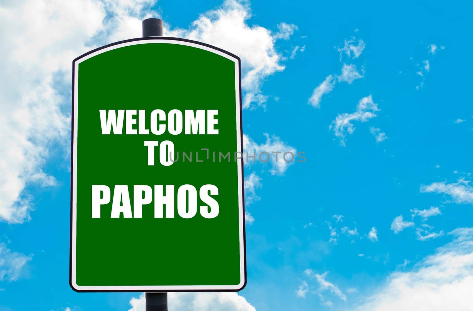 Green road sign with greeting message WELCOME TO PAPHOS isolated over clear blue sky background with available copy space. Travel destination concept  image