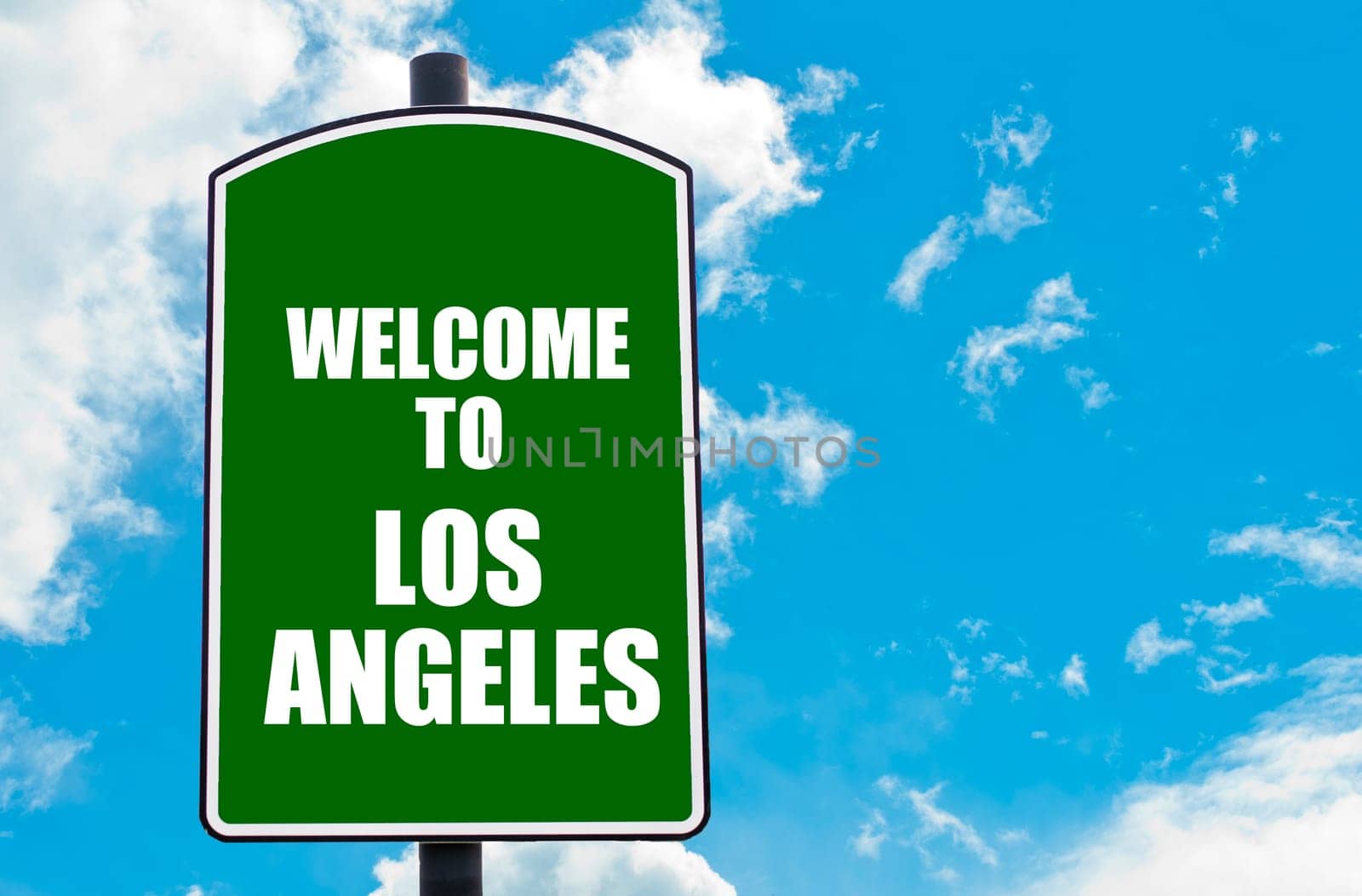 Green road sign with greeting message WELCOME TO  LOS ANGELES isolated over clear blue sky background with available copy space. Travel destination concept  image