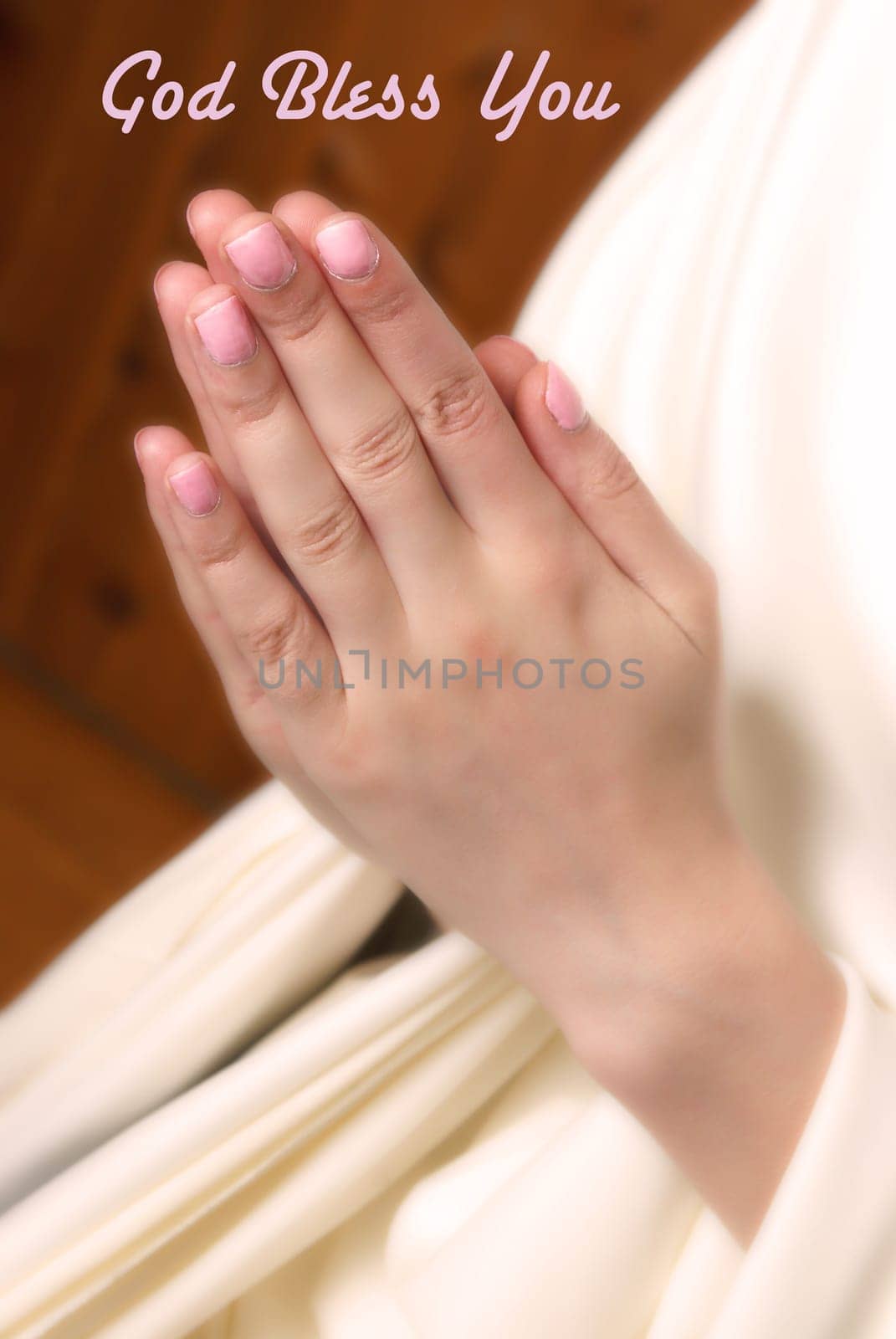 A young woman brings her hands together in prayer to the almighty father in heaven.