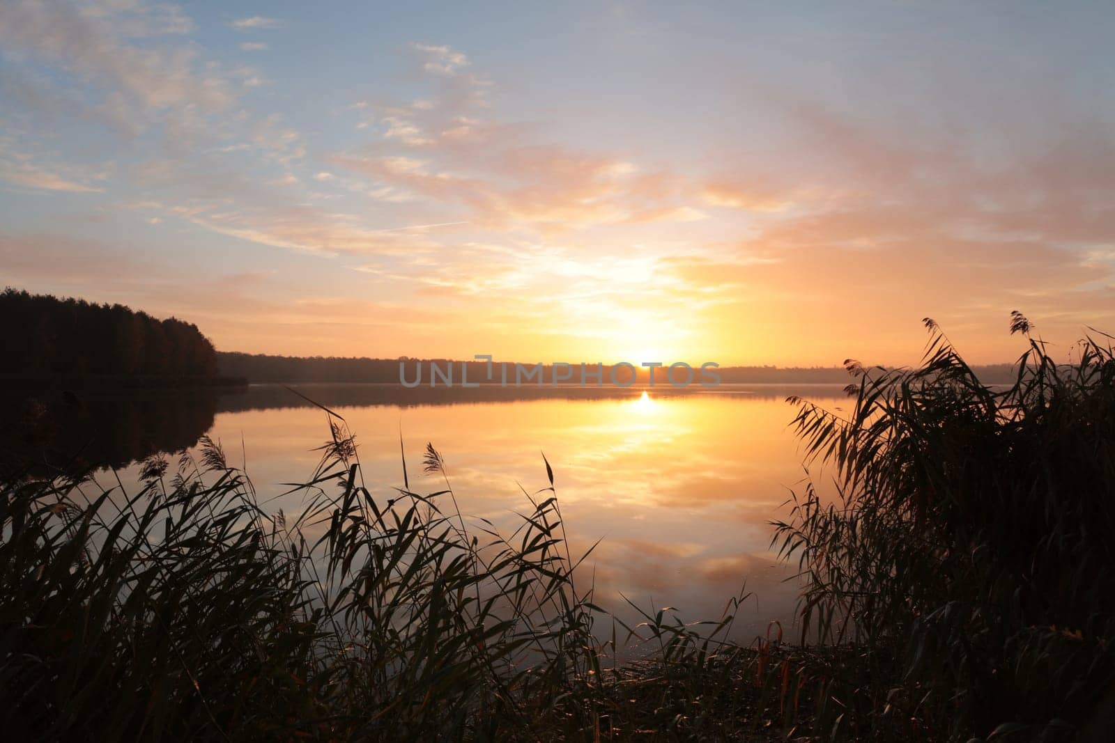 Sunrise over the lake on a cloudy autumn day.