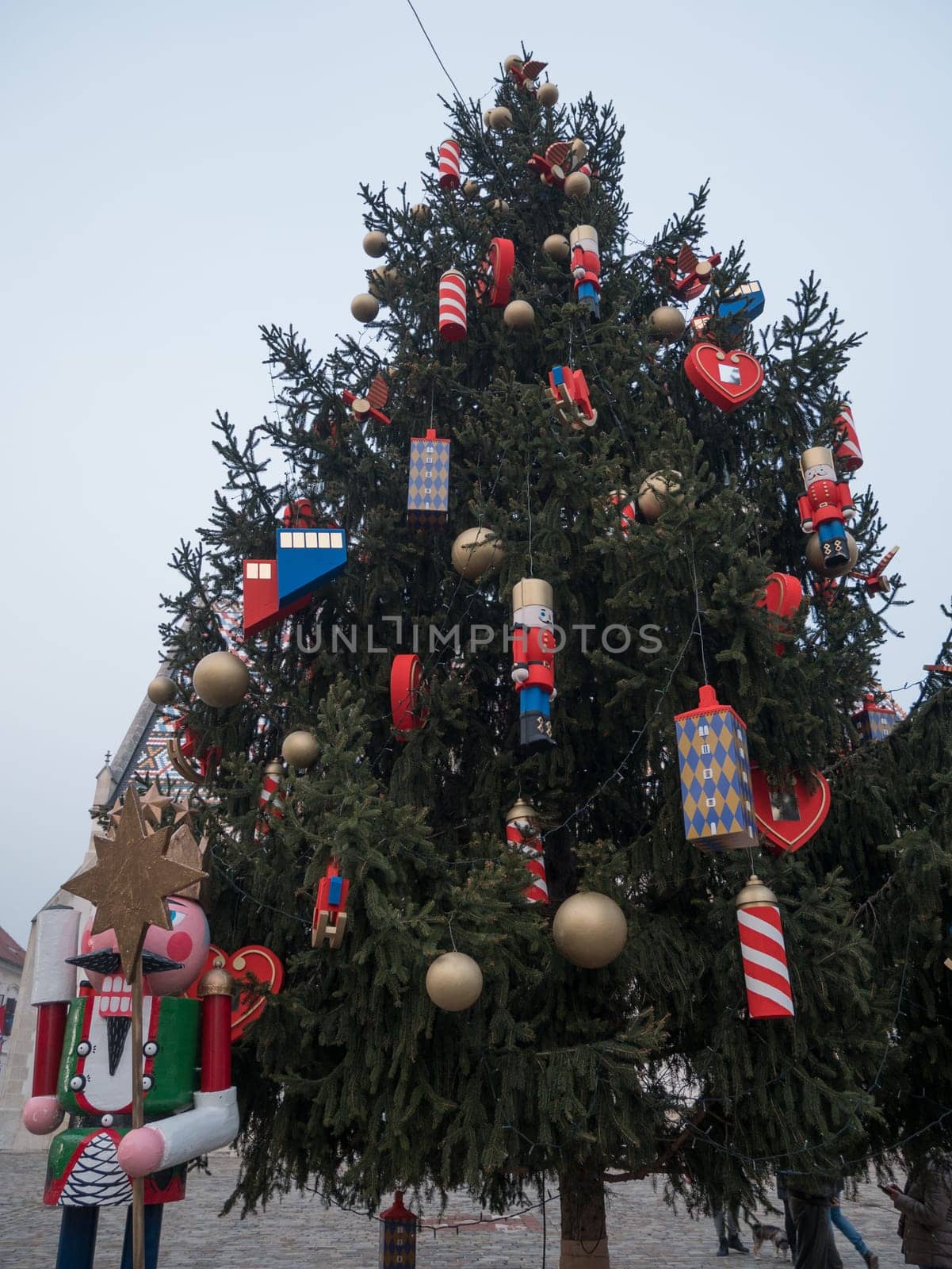 Big, green Christmas tree in the square on a day.