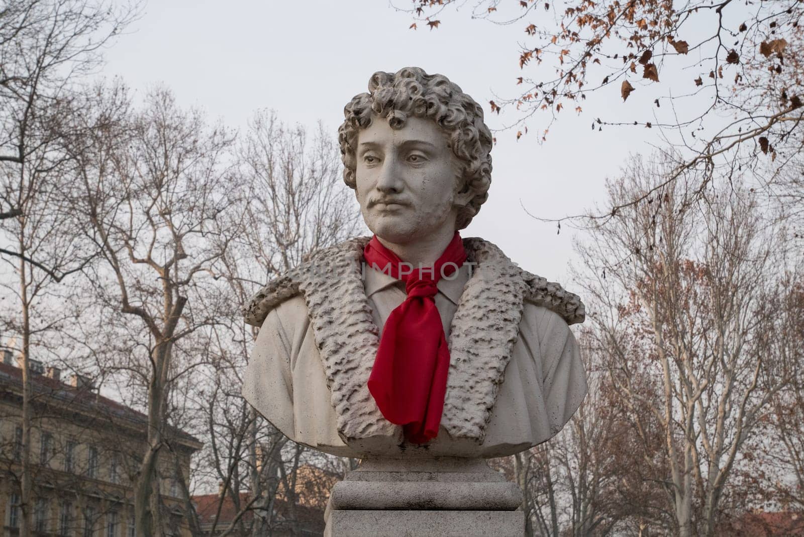 ZAGREB, CROATIA-January 4, 2020: Park Zrinjevac, sculpture of Croatian painter Andrija Medulic with red tie. Scripture is the work of sculptor Ivan Meštrovic.