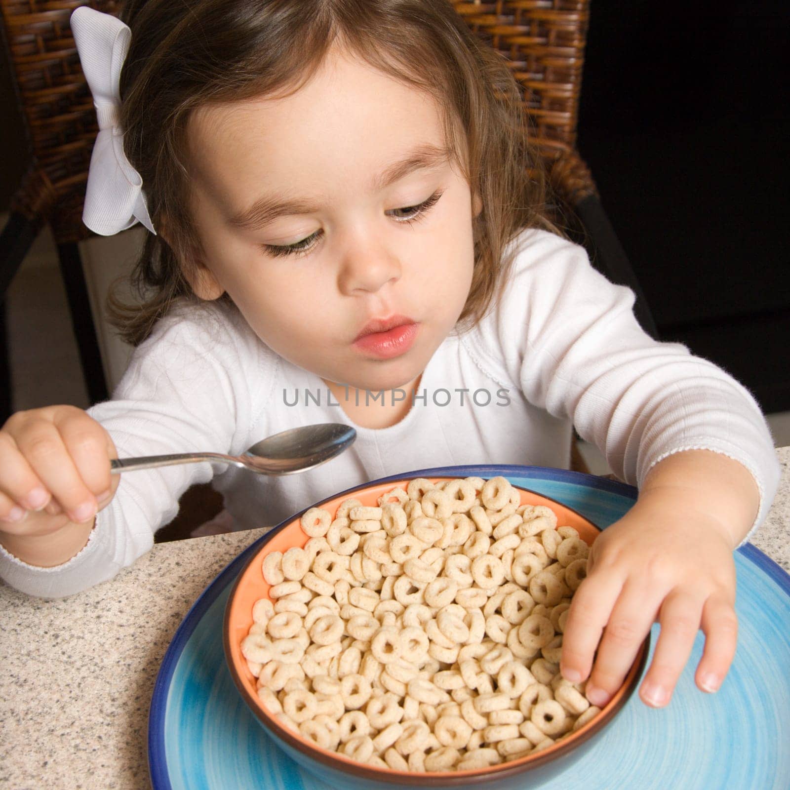 Caucasian girl eating bowl of cereal.