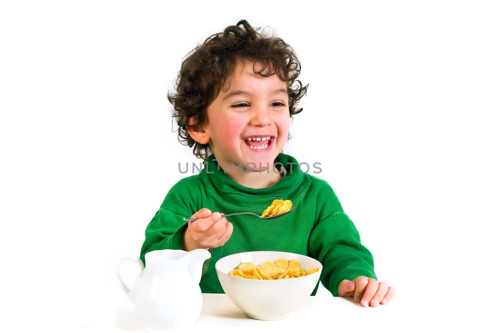 young boy eating cornflakes isolated on white