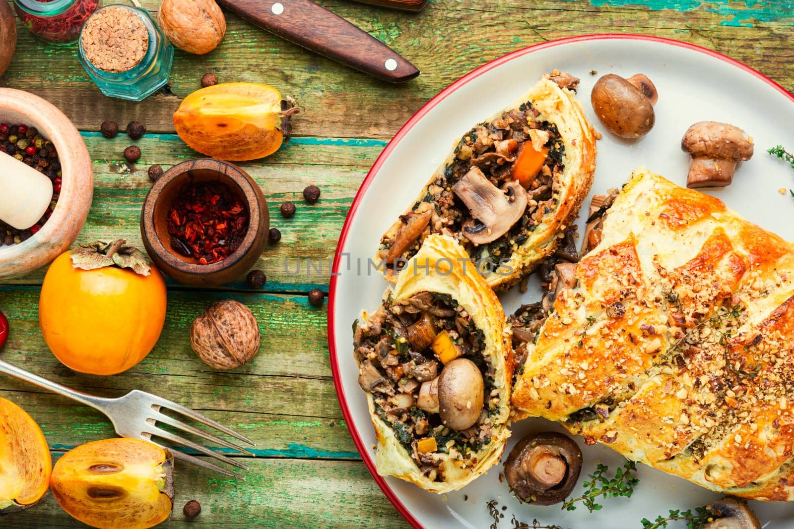 Piece closed homemade savory tart pie with mushrooms and persimmon