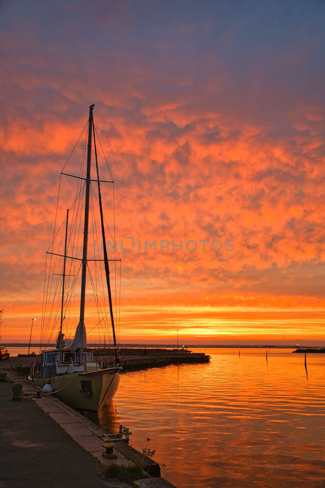 Sailing ship in the harbor of lake Vaettern at sunset. Lighthouse in the background. Landscape shot from Scandinavia